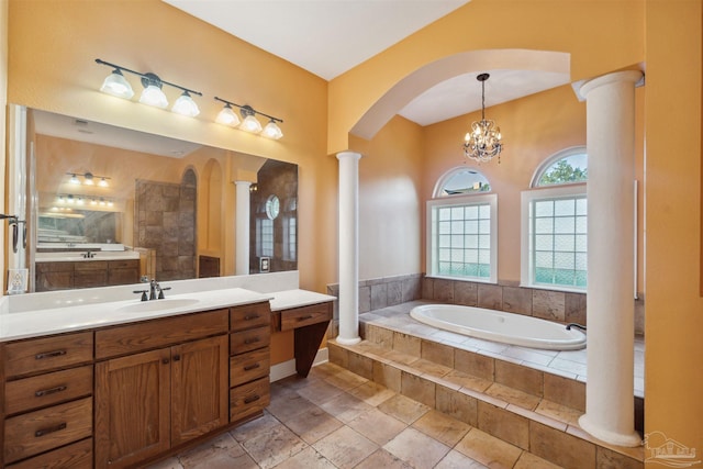 bathroom with vanity, a relaxing tiled tub, a notable chandelier, and ornate columns