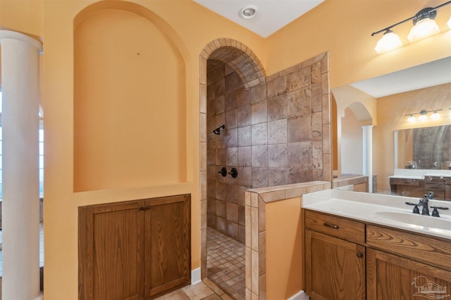 bathroom featuring a tile shower, vanity, and tile patterned floors