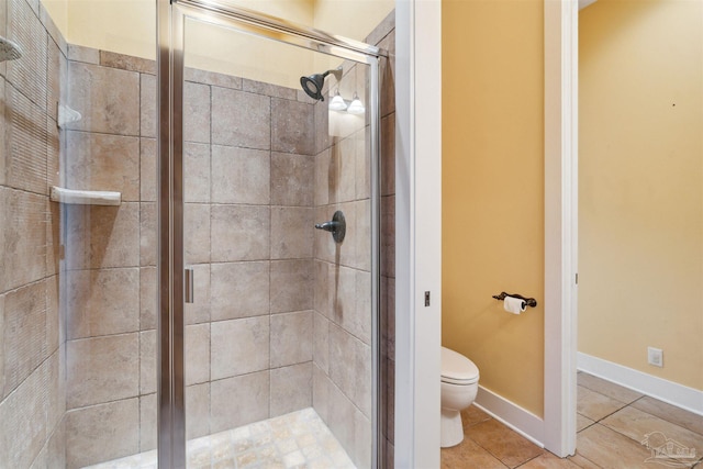 bathroom featuring toilet, tile patterned floors, and an enclosed shower