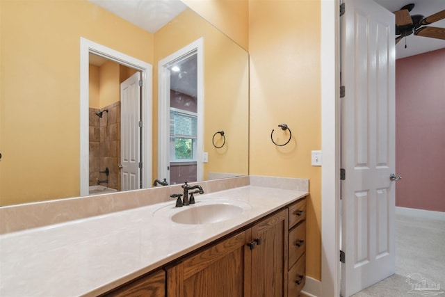 bathroom featuring tiled shower / bath, vanity, and ceiling fan