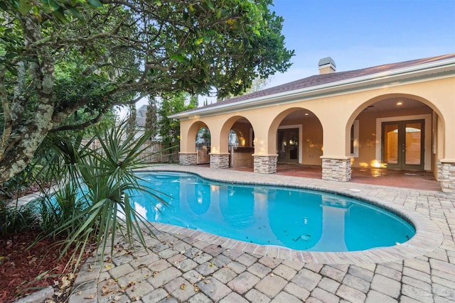 view of pool featuring french doors and a patio area