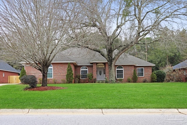 ranch-style home with a shingled roof, brick siding, and a front lawn