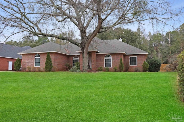 single story home featuring a shingled roof, a chimney, a front lawn, and brick siding