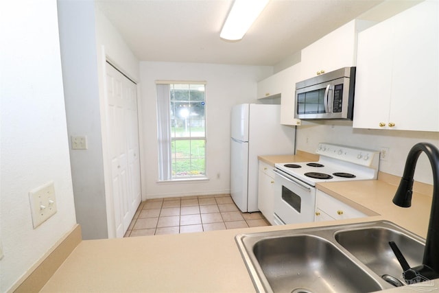 kitchen featuring light tile patterned floors, electric stove, white cabinetry, and sink