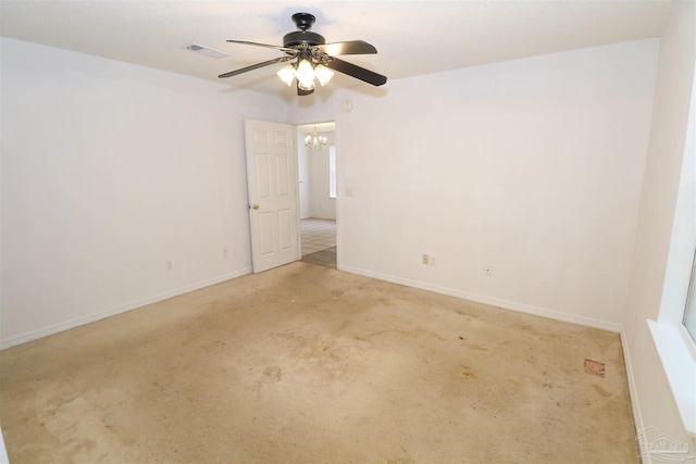 carpeted empty room with ceiling fan with notable chandelier