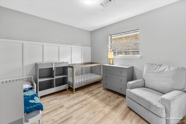 931 Pocahontas Dr, Ft Walton Beach, FL 32547 - bedroom with light hardwood / wood-style flooring and a nursery area