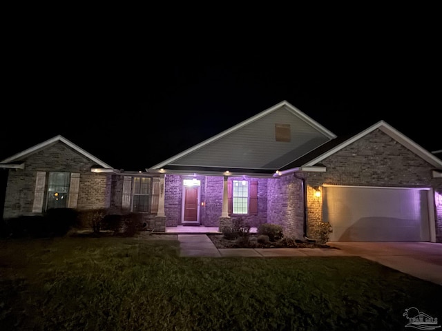 view of front of property featuring a garage, concrete driveway, and a yard