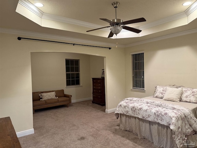 carpeted bedroom featuring baseboards, a tray ceiling, and ornamental molding