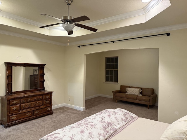 bedroom featuring a tray ceiling, ornamental molding, a ceiling fan, carpet flooring, and baseboards