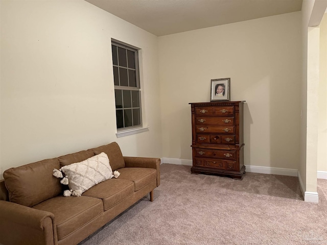 sitting room featuring light colored carpet and baseboards