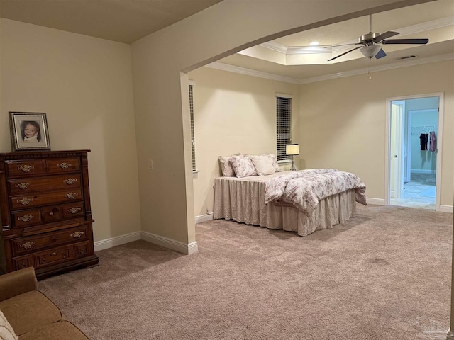 bedroom featuring crown molding, a tray ceiling, baseboards, and light colored carpet