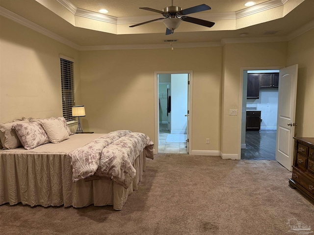 carpeted bedroom featuring visible vents, a raised ceiling, and ornamental molding