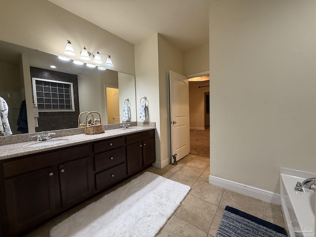 full bathroom with double vanity, baseboards, a sink, and tile patterned floors