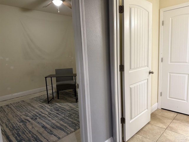 hallway with light tile patterned flooring and baseboards