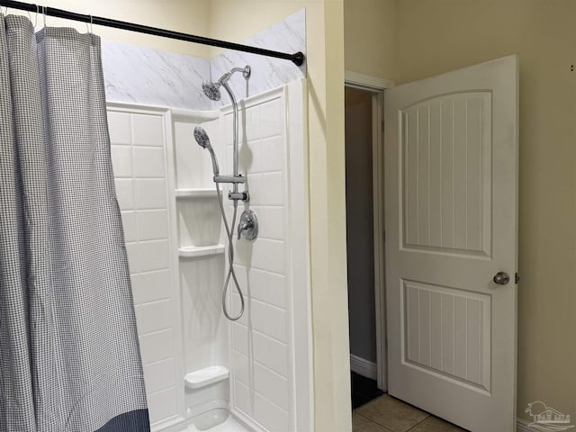 bathroom with a shower stall and tile patterned flooring