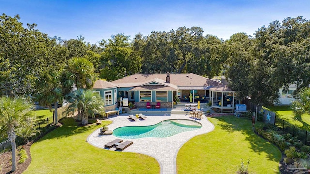 back of house with a fenced in pool, a yard, and a patio area