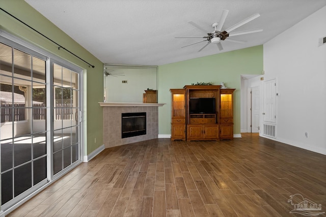 unfurnished living room featuring a textured ceiling, a fireplace, ceiling fan, and vaulted ceiling