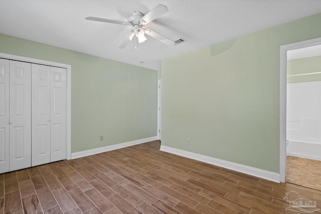 unfurnished bedroom featuring a textured ceiling, a closet, and ceiling fan