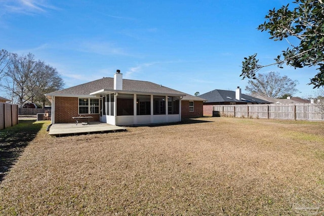 back of property featuring a patio area, a sunroom, and a lawn