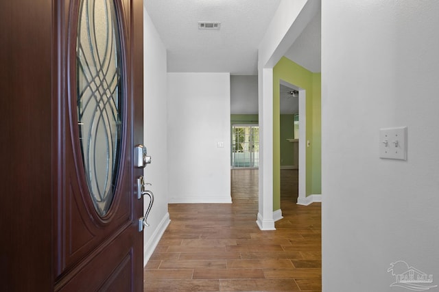 foyer with hardwood / wood-style floors and a textured ceiling