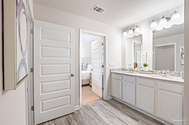 8815 Longmont Way, Milton, FL 32583 - full bathroom with ensuite bathroom, visible vents, a sink, double vanity, and wood finished floors
