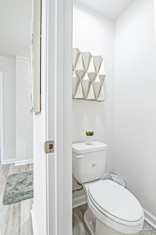 8815 Longmont Way, Milton, FL 32583 - bathroom featuring toilet, wood finished floors, and baseboards