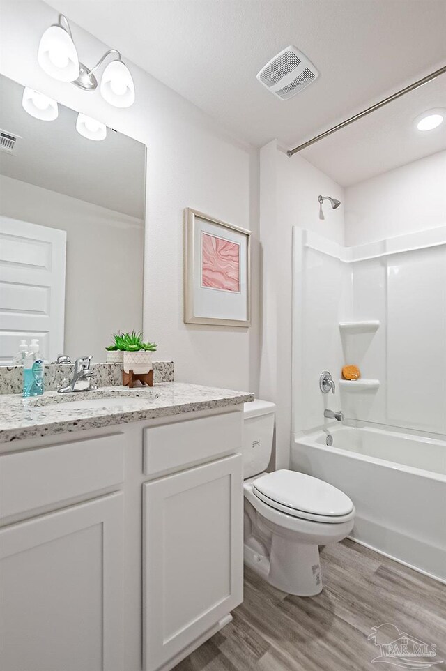 8815 Longmont Way, Milton, FL 32583 - bathroom with toilet, visible vents, vanity, wood finished floors, and washtub / shower combination