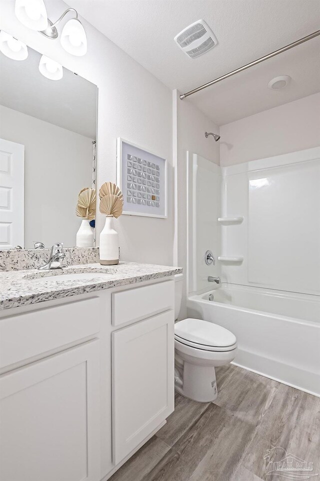 8815 Longmont Way, Milton, FL 32583 - bathroom with toilet, visible vents, vanity, wood finished floors, and washtub / shower combination
