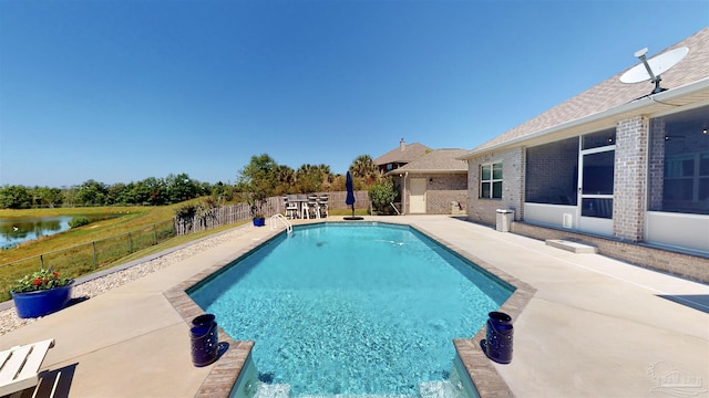 view of swimming pool with a patio area and a water view