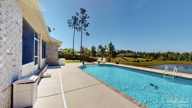 view of pool with a patio area and a water view