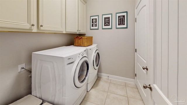 washroom featuring light tile patterned flooring, cabinets, and washing machine and clothes dryer