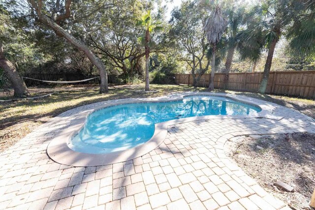 view of swimming pool featuring a fenced backyard, a fenced in pool, and a patio