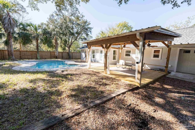 view of yard featuring a patio area, ceiling fan, fence, and a fenced in pool