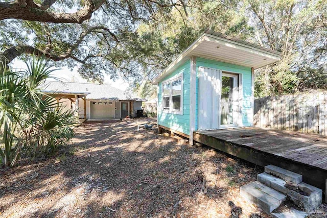 view of outbuilding featuring an outdoor structure and fence