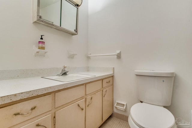 bathroom featuring toilet, vanity, and tile patterned flooring