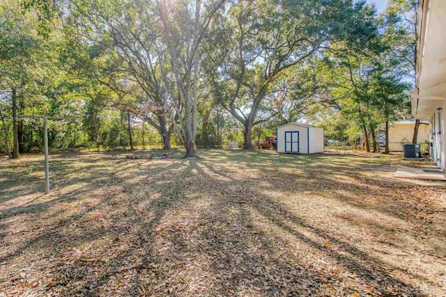 view of yard featuring cooling unit and a shed