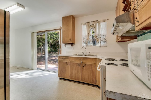 kitchen with white electric range oven, stainless steel fridge, and sink