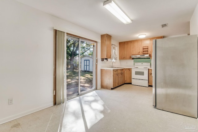 kitchen featuring sink, stainless steel fridge, and electric stove