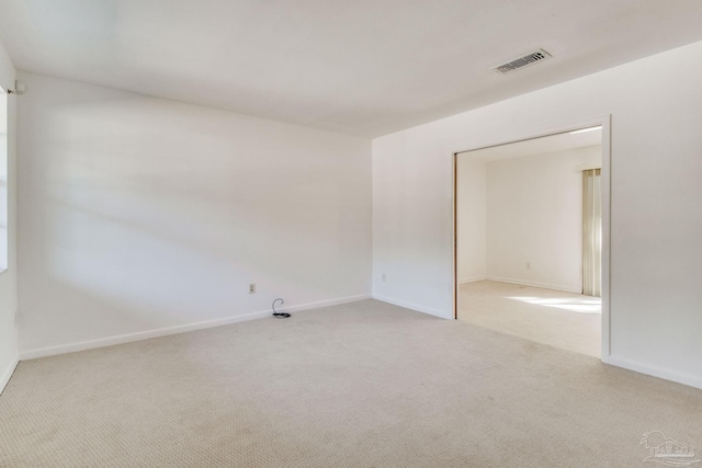 spare room featuring light colored carpet