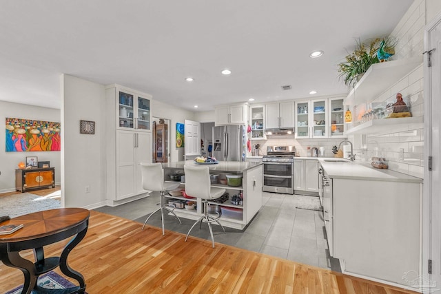 kitchen with appliances with stainless steel finishes, a center island, sink, and white cabinets