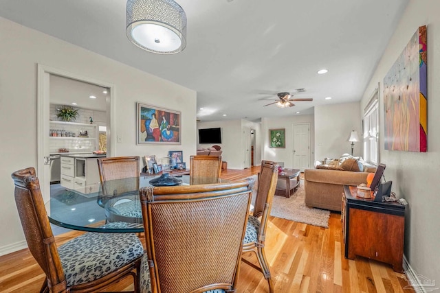 dining area with ceiling fan and light wood-type flooring