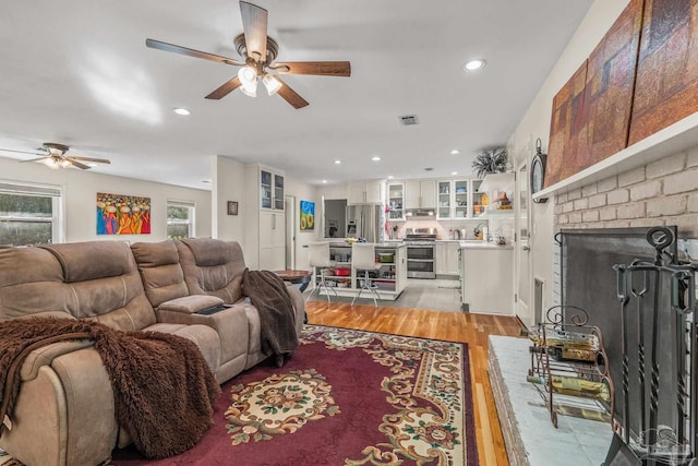 living room featuring ceiling fan and light hardwood / wood-style floors