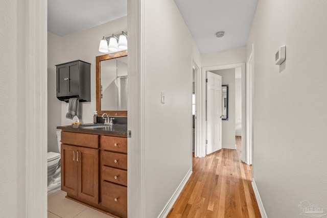 corridor featuring sink and light hardwood / wood-style flooring