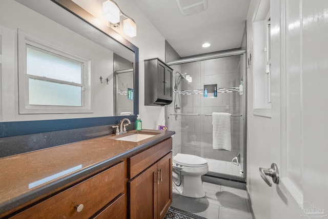 bathroom featuring tile patterned flooring, vanity, a shower with shower door, and toilet