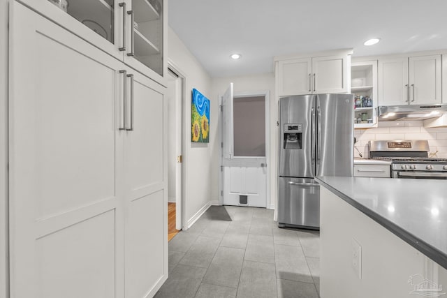 kitchen featuring appliances with stainless steel finishes, light tile patterned floors, decorative backsplash, and white cabinets