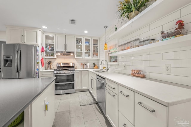 kitchen with white cabinetry, appliances with stainless steel finishes, decorative light fixtures, and sink