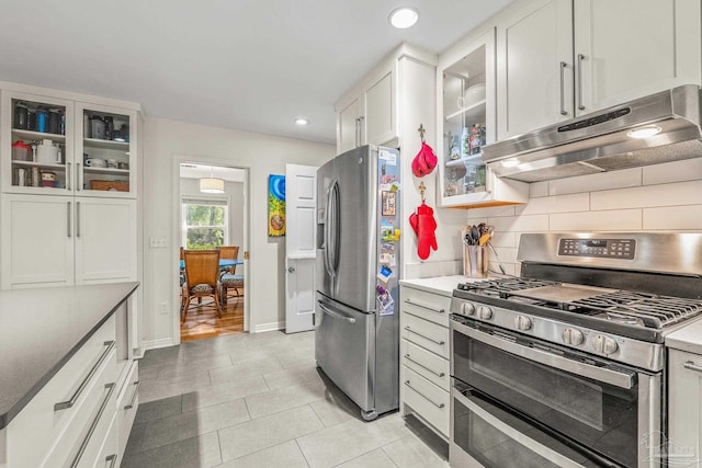 kitchen with white cabinetry, appliances with stainless steel finishes, light tile patterned flooring, and decorative backsplash