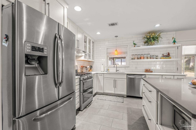 kitchen featuring sink, tasteful backsplash, appliances with stainless steel finishes, a healthy amount of sunlight, and white cabinets