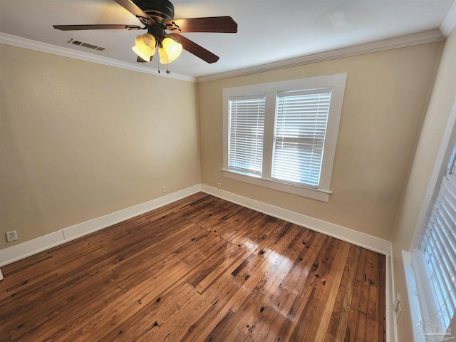 unfurnished room featuring dark wood-style flooring, a ceiling fan, visible vents, baseboards, and ornamental molding