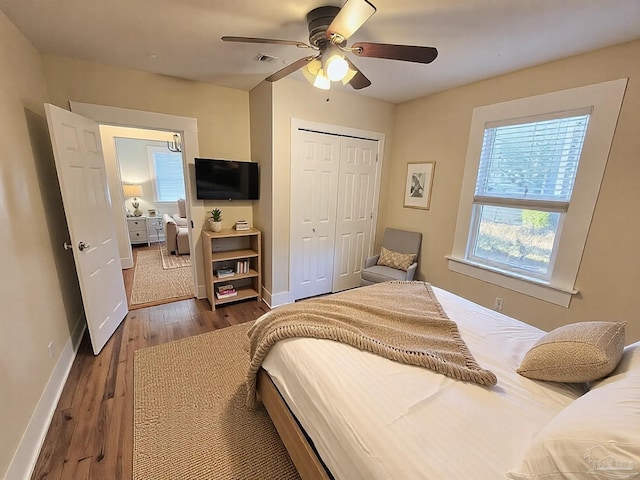 bedroom featuring a closet, multiple windows, wood finished floors, and visible vents